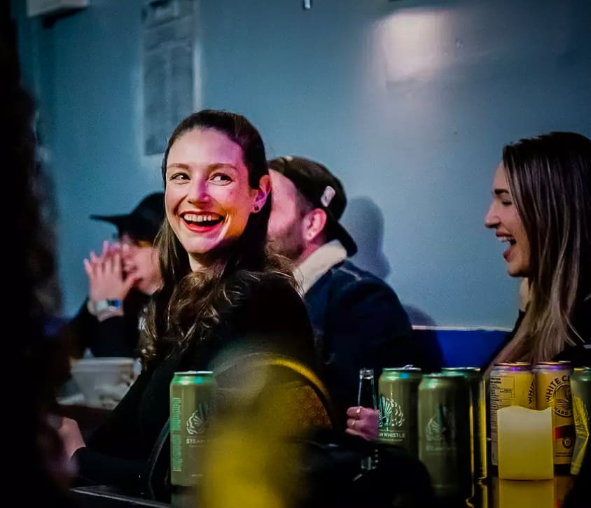Woman enjoying drinks at Backroom Comedy Club